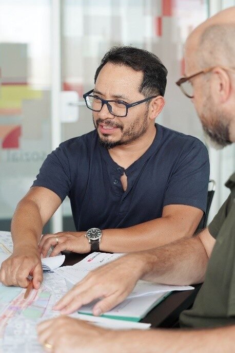 Jairon Roldán revisando planos técnicos en reunión de trabajo